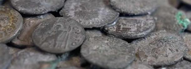 Un primer plano de algunas de las monedas romanas del tesoro de plata encontradas en el sitio de construcción en Augsburgo, Baviera, Alemania. (Captura de pantalla de YouTube/tagesshau)