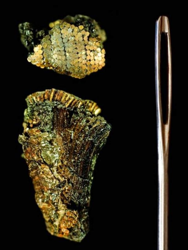 Detail of the decoration of the dagger handle, shown next to a sewing needle for scale. The studs were placed in straight lines and the heads overlapped each other like fish scales.