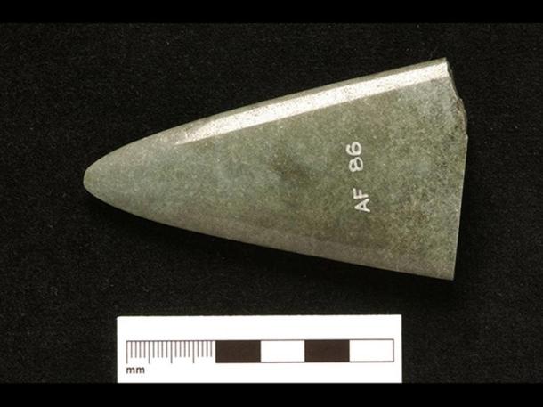 Fragment of deliberately-broken axehead, found near Douglas Castle, South Lanarkshire. The straight line along the bottom is due to the removal of a slice to make a petrological thin section during the 1960s.