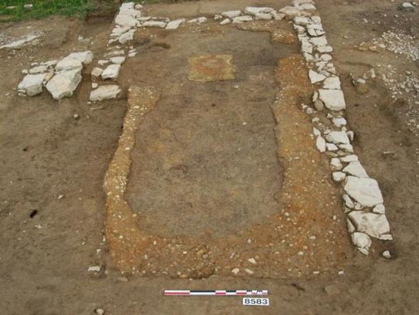 The dining room of the ancient tavern, showing banks of pebbles where built-in benches once stood against the walls.