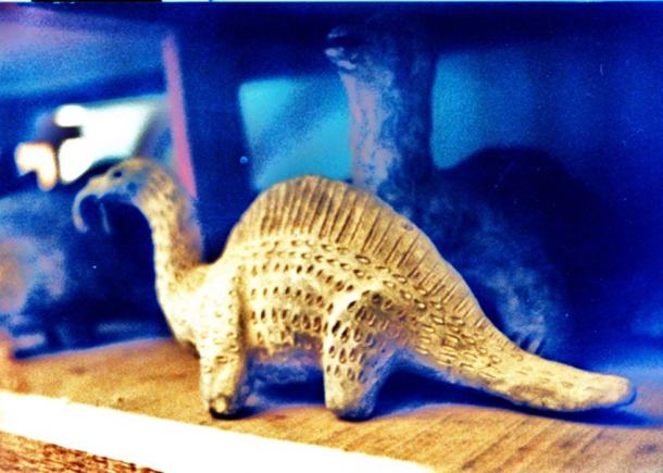 What appears to be a dinosaur sculpture in the collection of strange artifacts. 