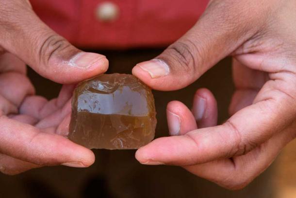 Archaeologist displays a French musket flint recovered from one of the Continental burials. (Sarah Nell Blackwell / South Carolina Battleground Trust)