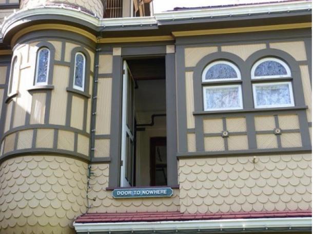 A door in the Winchester Mystery House opening out onto a three-story drop, now labelled “Door to Nowhere.”