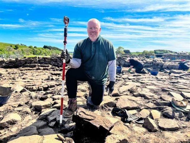 Dylan Herbert, a retired biochemist from South Wales, was volunteering with the Vindolanda Trust when he discovered the carved penis and insult, shown here just to the right of his left foot. (Vindolanda Charitable Trust)