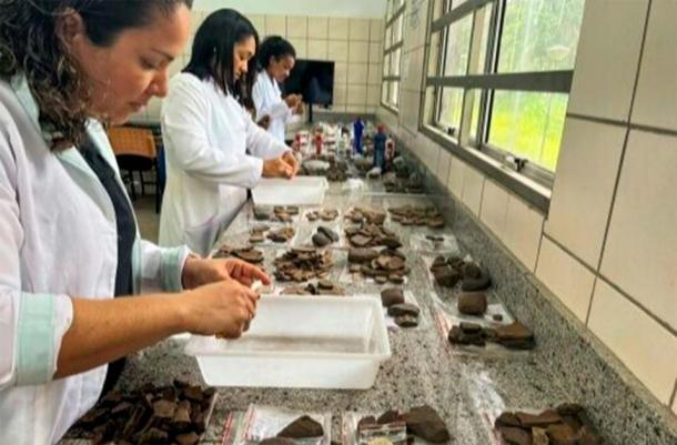 Experts examine ceramic fragments unearthed at a construction site in the apartment complex in Sao, Luis Brazil. (Iphan/Handout)