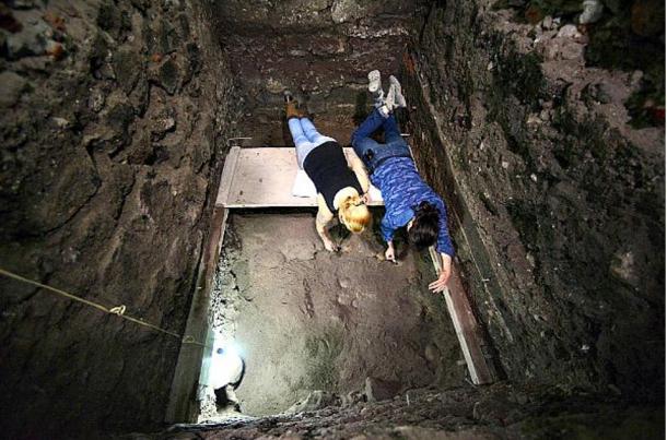 Members of the archaeological team working on wooden platforms in an excavation well. 