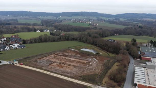 Aerial view of the excavation site for the new fire station on Lohagenweg in H&uuml;llhorst. The line of trees marks the course of the spring stream that once provided the foundation for the original farmstead. Photo: LWL-AfW / A. Koch