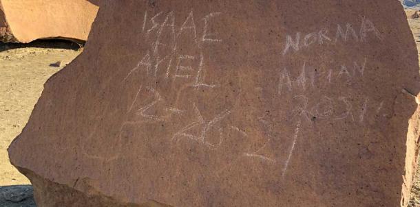 The surface of a petroglyph stone in the Indian Head area of Grand Bend National Park, where four vandals wrote their names and the date on December 26, 2021. Source: National Parks Service
