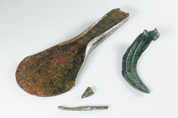 : A collection of Bronze Age objects found at the site, including the axe, dress pin, and sickle