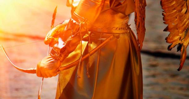 Gold Eros, Greek god of love representation close up on middle body, bow and arrow. Source: zwiebackesser / Adobe Stock