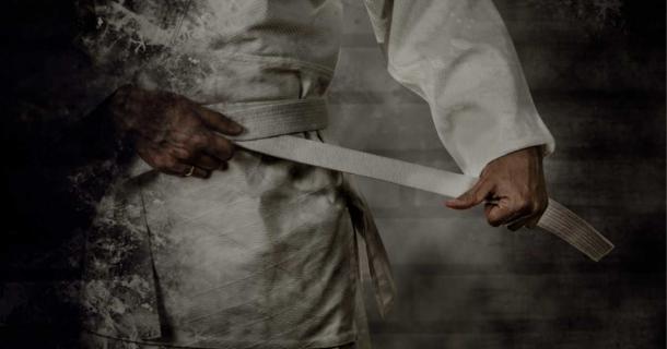 Jujutsu practitioner tightening their belt. Source: Soloviova Liudmyla / Adobe Stock