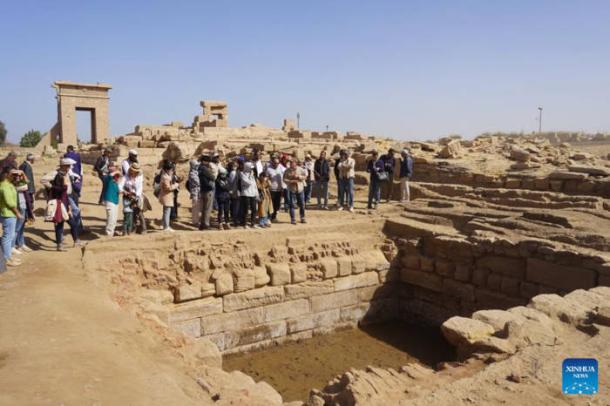 : Guests visit the ruins of the &ldquo;sacred lake&rdquo; at the Montu Temple precinct, Karnak, Luxor.