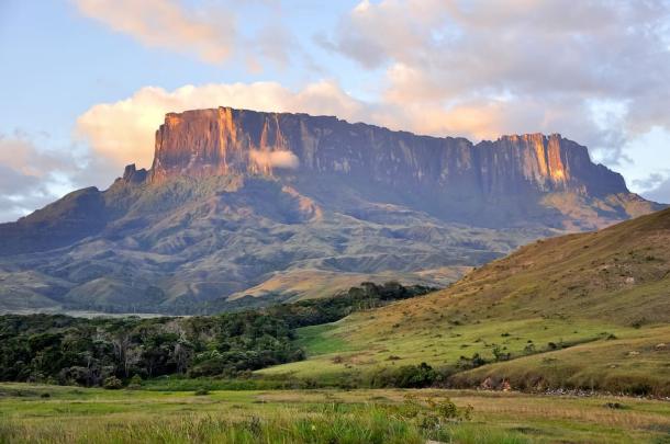 A beautiful, wide-angle shot of the neighboring Kukenan tepui at sunset, showing the massive, seemingly 