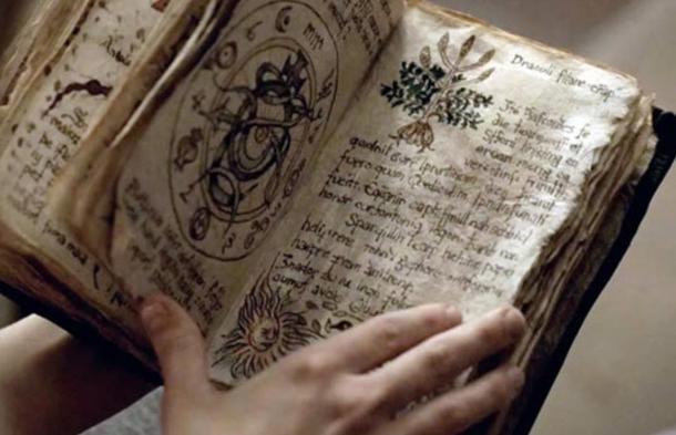 Person holding an ancient grimoire filled with spells, curses, and incantations