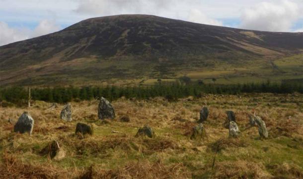 Prehistoric Irish monuments of Late Bronze Age stone circle at Boleycarrigeen, with Keadeen cursus near the summit of the mountain in the background Source: J. O’Driscoll/Antiquity