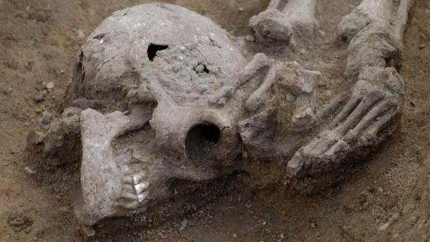 This photo shows one particular body where the head has been lopped off and placed at the feet of the victim found at the Roman burial site, Somersham, UK.