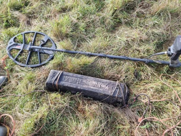 A lead ingot near the find site, with the metal detector that found it.