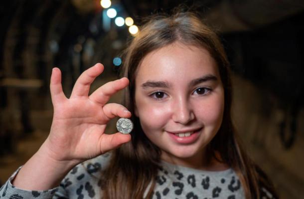 Volunteer Liel Krutokop with the rare silver Second Temple coin she found at the City of David National Park. Source: Yaniv Berman / City of David