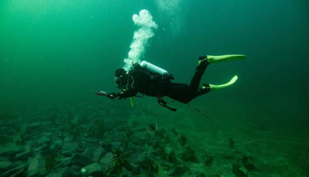 Marine archaeologist Christopher F. Kv&aelig;stad documents the stone belt in Grindasundet, Norway