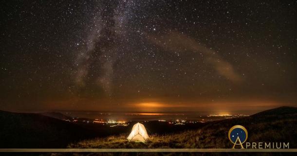 Milky way seen from a grassy summit in, Nantlle Valley in Gwynedd, Wales.( Chin / Adobe Stock)