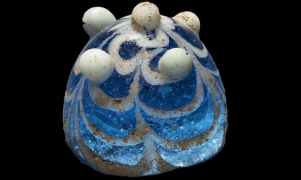 The glass artifact thought to be a Viking game piece discovered in Lindisfarne. Source: Jeff Veitch / Durham University.