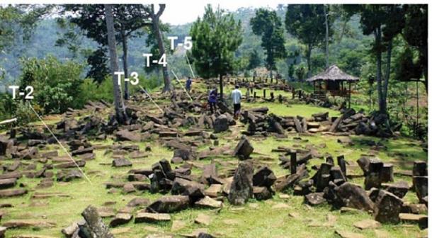 Grassy hilltop terrace scattered with dark columnar andesite blocks, with labels T-2 to T-5