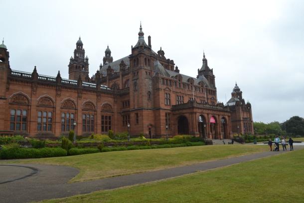 Red sandstone exterior of Kelvingrove Art Gallery and Museum behind a lawn