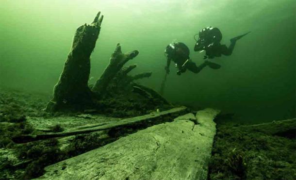 The authors at the stern of the wreck where the standing bottom logs and stern are seen sticking up from the seabed, seen from the starboard side. Source: Florian Huber/Stockholm University.