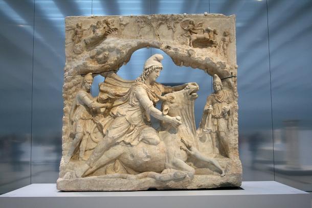 A marble relief showing the Roman god Mithras in a cap kneeling on a bull and slaying it