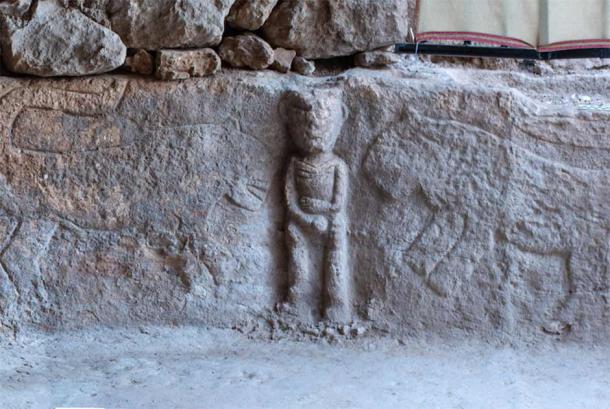 The right side of the Neolithic Anatolian stone relief depicting a male figure holding his phallus in the middle with leopards on either side.