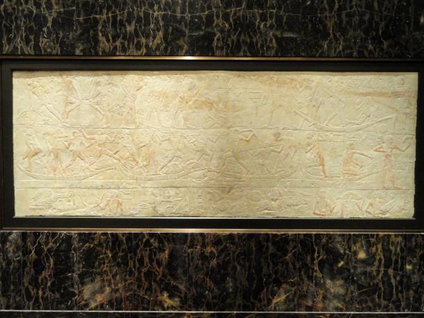 A limestone relief carved with rows of offering bearers and hieroglyphs from an Old Kingdom tomb at Saqqara