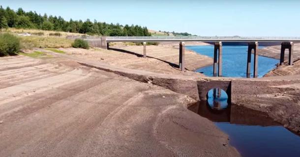 The sunken village of Baitings and its famous packhorse bridge, pictured below the modern car bridge, have been exposed by record drought and heat for the first time since the mid-1950s. Source: YouTube screenshot / velomoho
