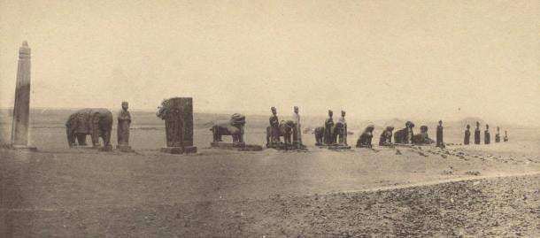 A long line of stone animals and figures standing on open ground along the spirit way of Yongxi Mausoleum, photographed in 1918