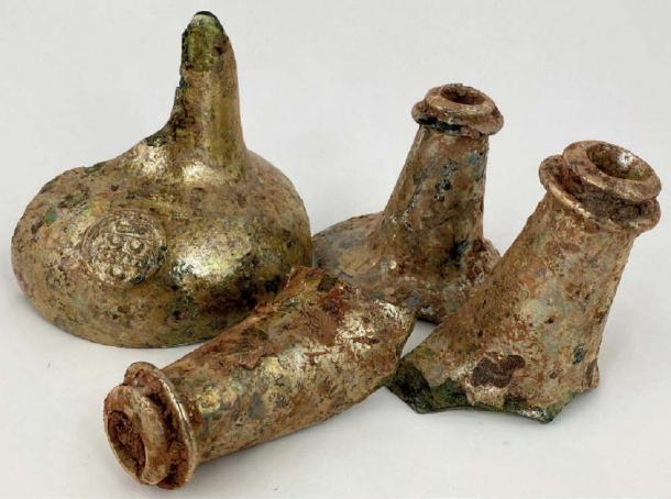This group of four neck fragments, including one with a seal, found with wine bottles. (©BBR Auctions)