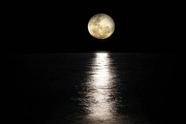 A full moon over water.