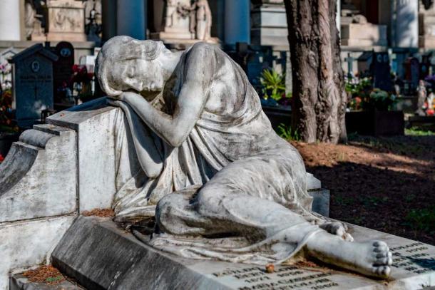 Statue of a woman lying on top of the grave of her deceased husband (BTWImages / Adobe Stock)