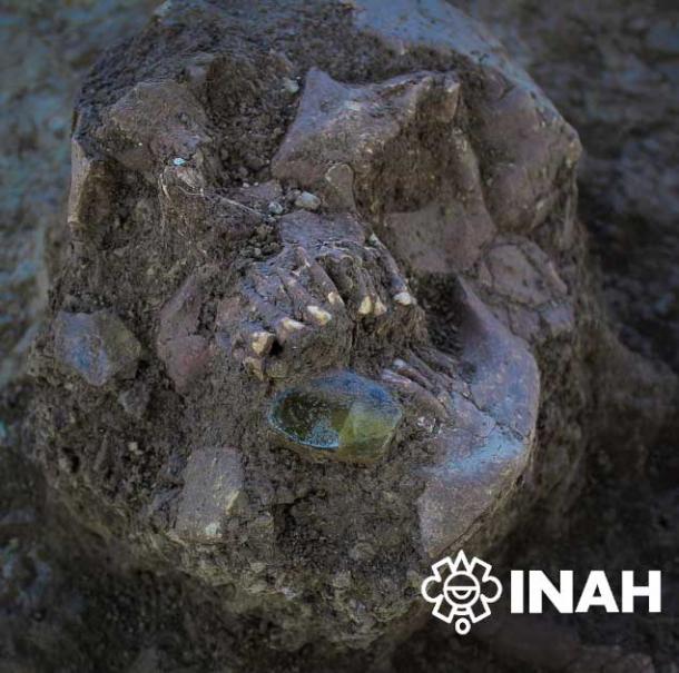 A green quartz gemstone in the mouth of one of the deceased. (INAH)