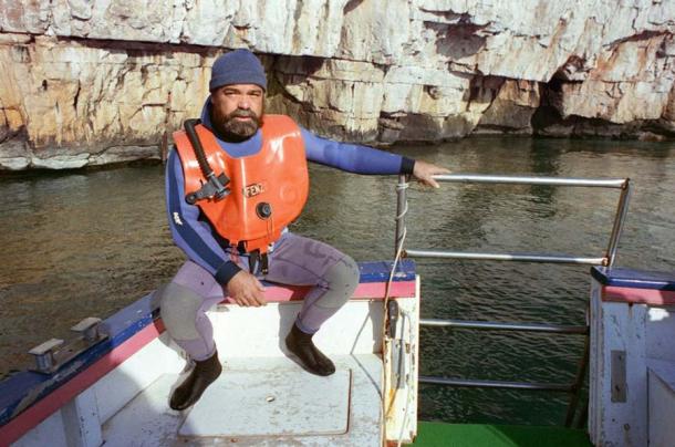 Henri Cosquer, the diver who found the cave, photographed on a boat above the entrance in 1991 (AFP)
