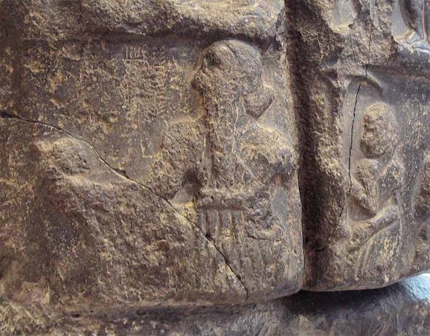 Sargón en su estela de la victoria, seguido por un asistente que sostiene un paraguas real. El nombre de Sargón en escritura cuneiforme ("Rey Sargón") aparece débilmente frente a su rostro. Museo del Louvre (CC BY-SA 2.0)
