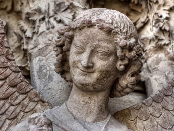 A smiling angel, yet so humanlike, that was carved in stone at the Reims Cathedral, France. Could this also be a medieval self portrait of the master stonemason who made this work? (Jorge Alves / Adobe Stock)