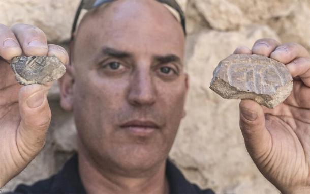 Dr. Yiftah Shalev, from the Israel Antiquities Authority, with the Persian-era seal and seal impression, both discovered in the excavation of a parking lot in Jerusalem. (Shai Halevy / Israel Antiquities Authority)