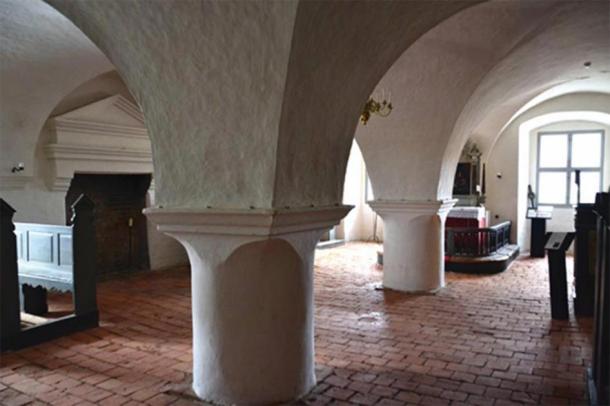 The chapel with brick vaults and the fireplace to the left. The borderline between the circular higher half and the plain, straight lower half is clearly emphasized, having yin-yang-like opposite joints where columns meet vaults. (Author provided)