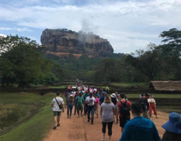 Author (far left) approaching Sigiriya. Working your way through the complex of masterfully crafted gardens and selfie-sticks that surround the giant citadel is just part of the fun. (F. Burnand / Photo courtesy of the author)