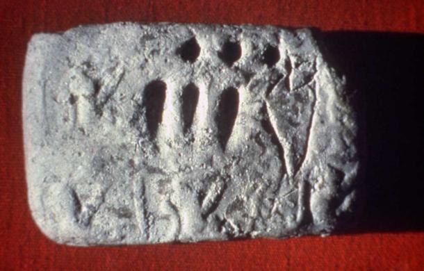 Impressed and incised tablet from Godin Tepe, Iran, circa 3100 BC. The circular imprints stood for tens and the wedges for units. The incised figure to the right is a depiction of a jar of oil, and this tablet was a record of, in total, 33 jars of oil.