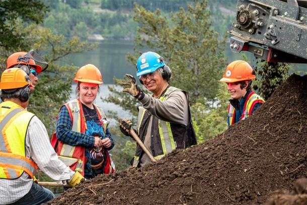 Team inspects an artifact found on site while processing soil piles at Williams Lake. (Sugar Cane Archeology)