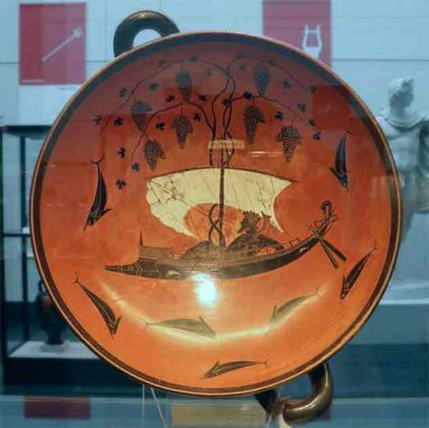 A famous black figure kylix by Exekias. It depicts the god of wine, Dionysus, on a ship. A myth says that pirates tried to abduct him, but he transformed them all into dolphins and made vine leaves spring from the mast to act as sails. (Carole Raddato/CC BY SA 2.0)