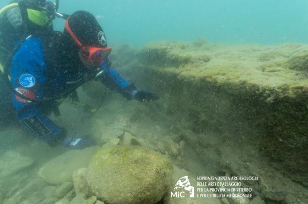 A marine archaeologist examines part of the structure. 
