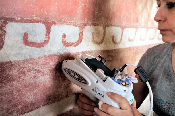Un miembro del equipo interdisciplinario del INAH utiliza equipo especializado para identificar minerales de pared mesoamericanos previamente desconocidos en una pintura mural del complejo Quetzalpapálotl. (Denisse Argote Espino/INAH)