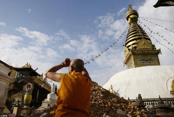 Known as the monkey temple, the Swayambhunath Stupa complex was largely destroyed except for its iconic golden tower. A monk surveys the damage.