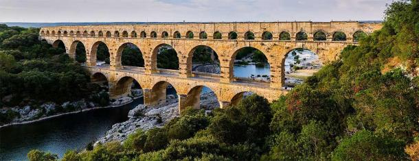 Los múltiples arcos del acueducto romano de Pont du Gard en el sur de Francia de hoy. El nivel superior contiene un acueducto que transportaba agua a Nîmes en la época romana; su nivel inferior se amplió en la década de 1740 para llevar un camino ancho a través del río. (CANCIÓN DE UBICACIÓN Benh / CC BY-SA 3.0)